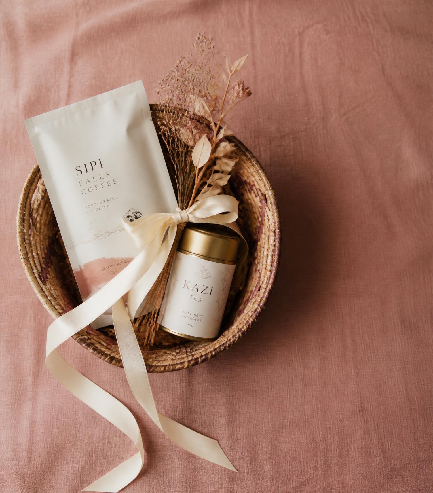 A handmade gift basket with coffee and tea, tied with cream silk